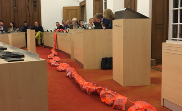 Filmpje: Raadsleden komen met honderden zwembandjes naar raadszaal